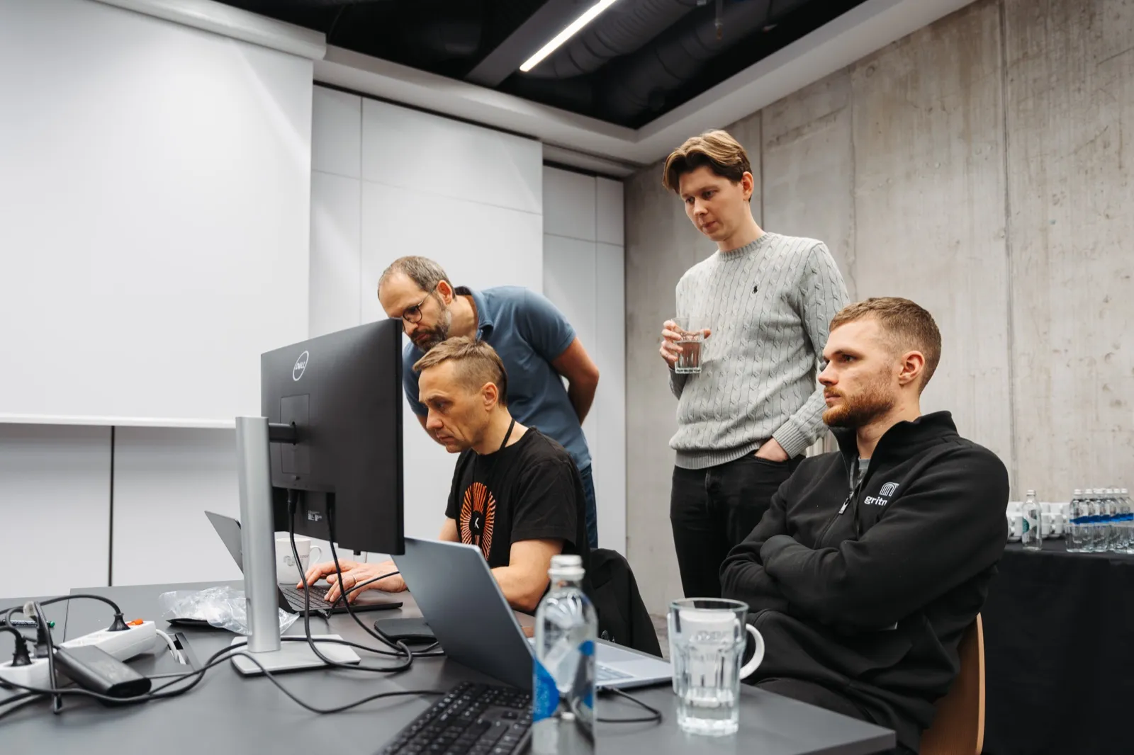 Four engineers gathered around one screen during a hackathon