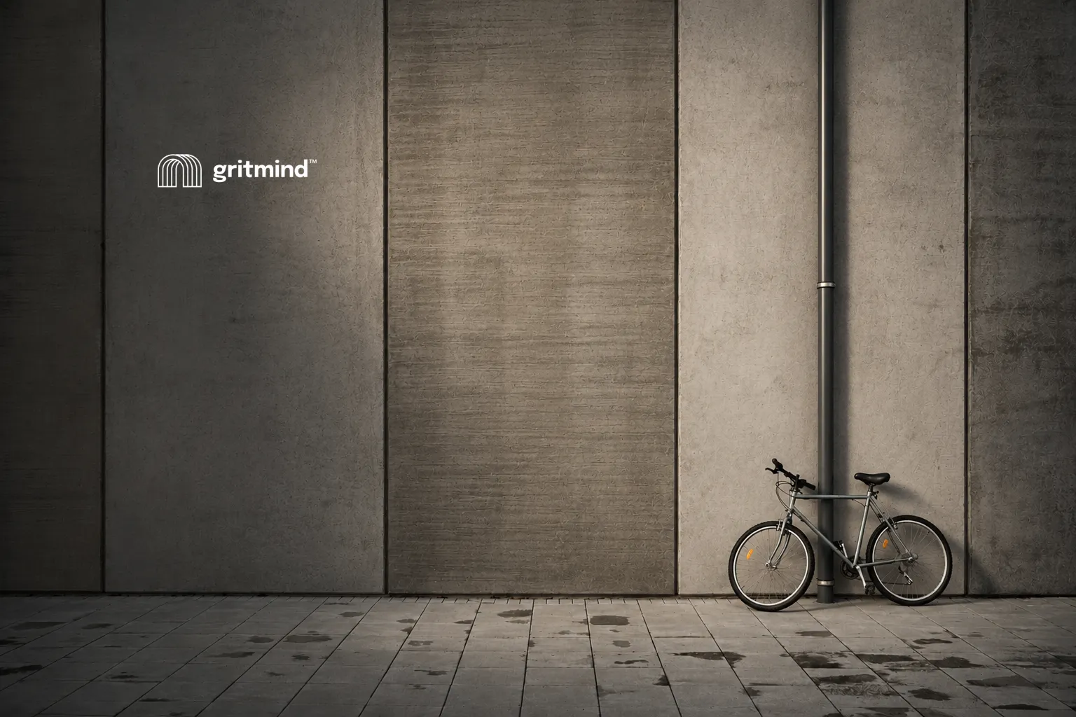 Illustration of a bicycle leaning against a concrete wall next to the Gritmind logo