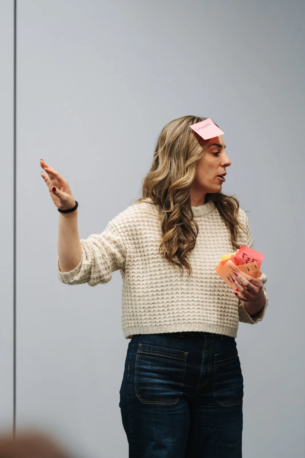 A facilitator sorting sticky notes, one stuck to her forehead